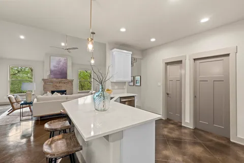 a kitchen with a table chairs refrigerator and couches