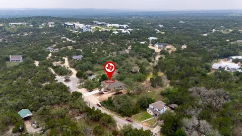 an aerial view of residential houses with outdoor space and trees