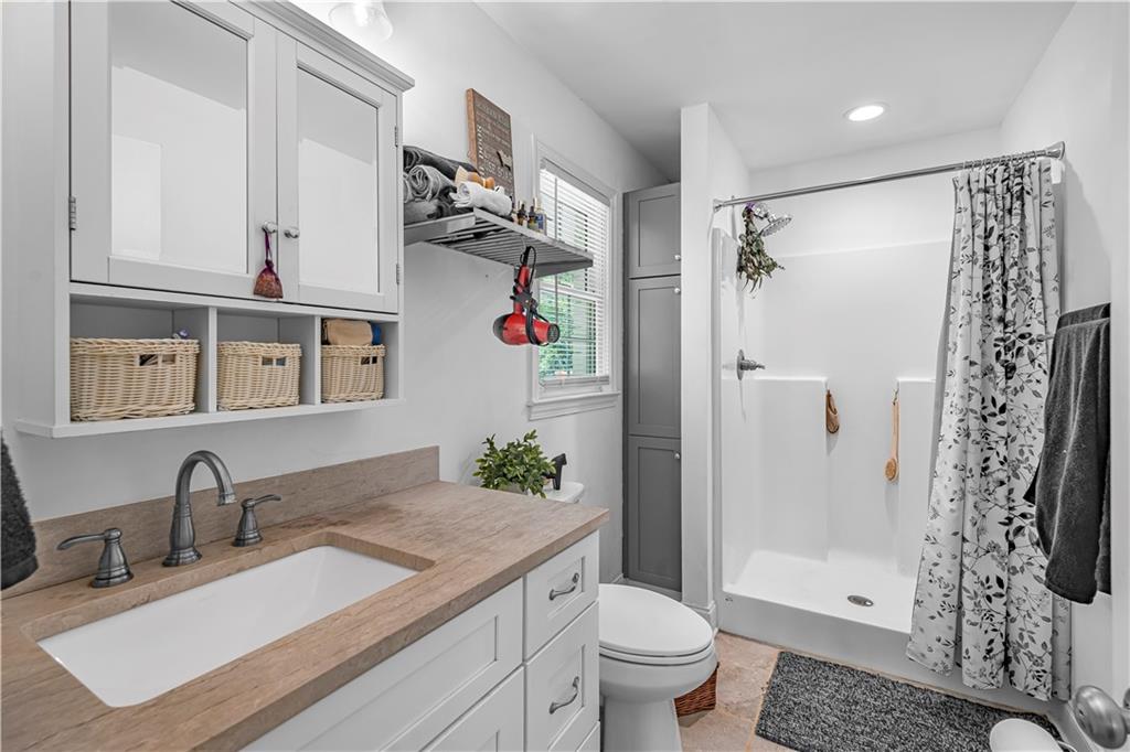 2383 Sperin Road Ball Ground, GA 30107 - Photo 13 of 38 a bathroom with a granite countertop sink toilet and shower