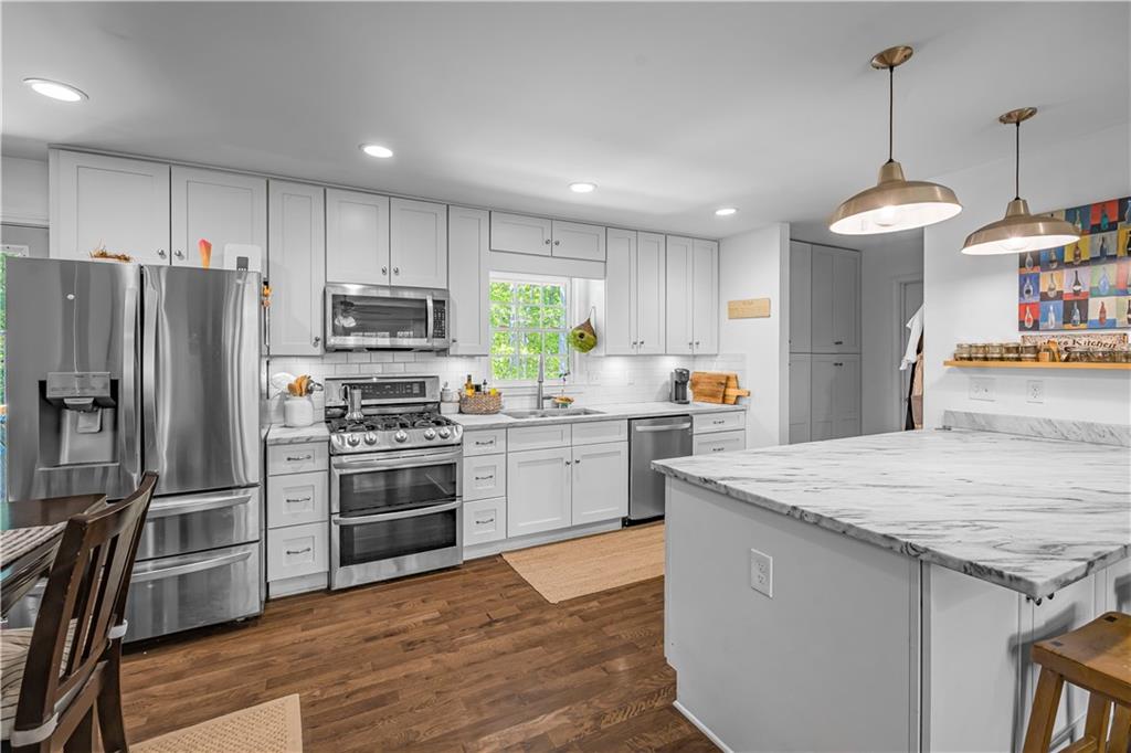 2383 Sperin Road Ball Ground, GA 30107 - Photo 5 of 38 a kitchen with stainless steel appliances granite countertop a stove refrigerator and a sink