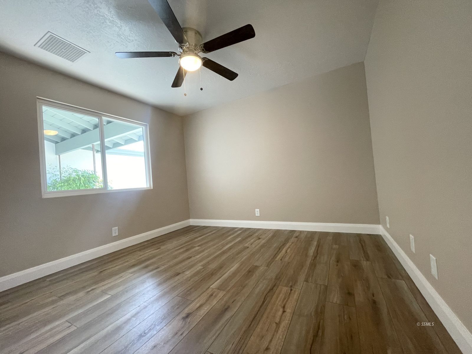 1031 North Sierra View Street Ridgecrest, CA 93555 - Photo 15 of 33 wooden floor in an empty room with a window