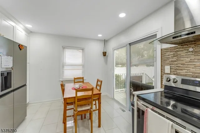 a kitchen with a stove a refrigerator and furniture