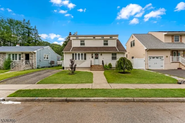 a view of a white house with a yard table and chairs