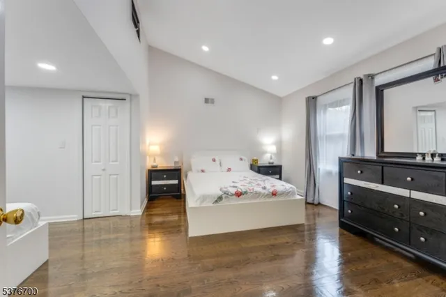 a spacious bedroom with a bed and a dresser in it