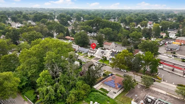 an aerial view of residential houses with outdoor space and trees