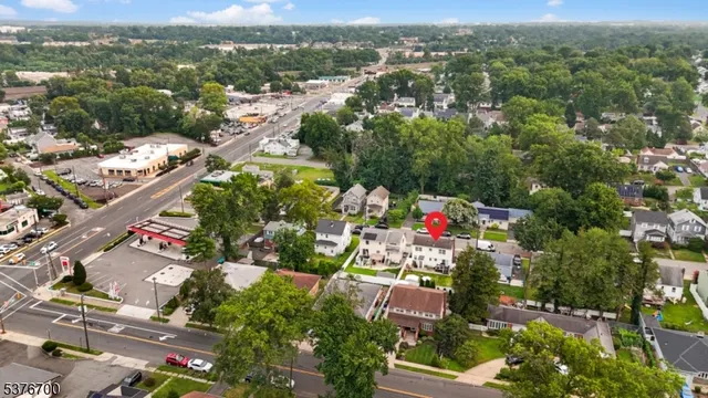 an aerial view of a houses with a lush green hillside