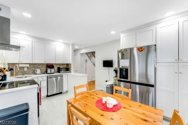 a kitchen with stainless steel appliances kitchen island granite countertop a refrigerator stove microwave and sink