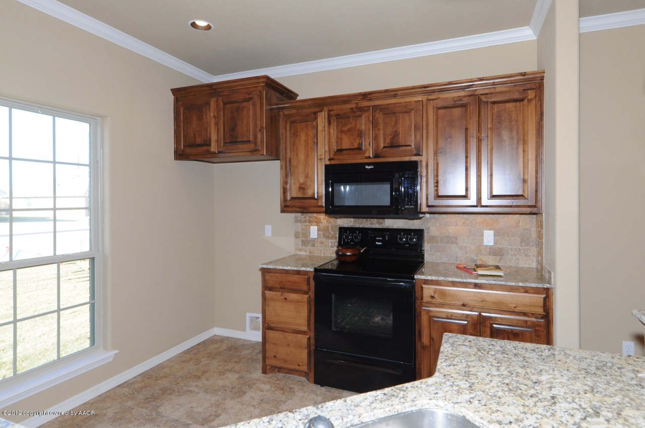 5903 South Rusk Street Amarillo, TX 79118 - Photo 6 of 16 a kitchen with stainless steel appliances granite countertop a stove and a microwave