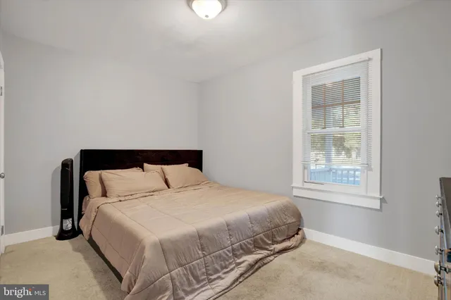 a large bed sitting in a bedroom next to a window