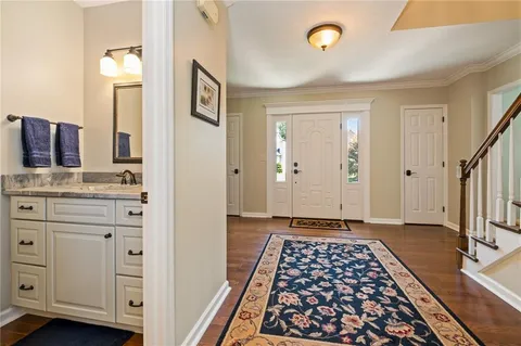 a view of a hallway with wooden floor and cabinet