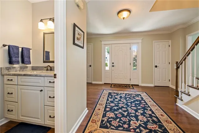 a view of a hallway with wooden floor and cabinet