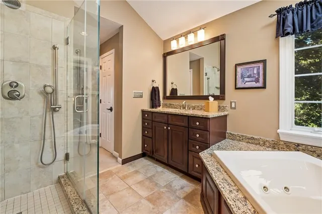 a bathroom with a tub sink and mirror