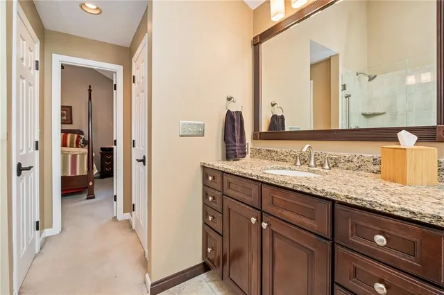 a bathroom with a granite countertop sink and a mirror