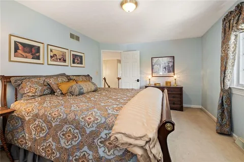 a bedroom with a bed and a painting on the wall