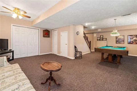 a living room with furniture a flat screen tv and a wall painting