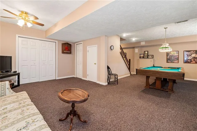 a living room with furniture a flat screen tv and a wall painting