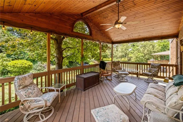 a view of a patio with couches chairs and wooden floor