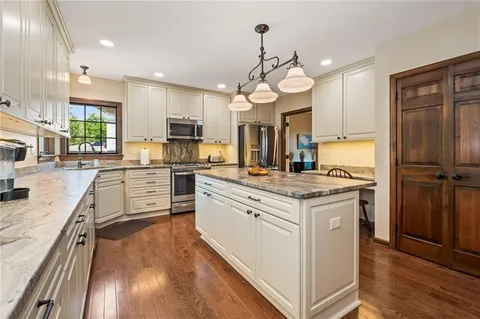 a kitchen with stainless steel appliances granite countertop a stove and a refrigerator