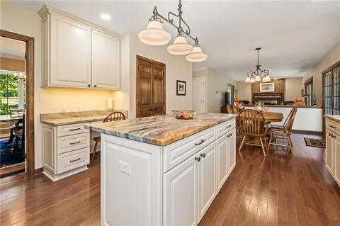 a kitchen with a stove a sink a dining table and chairs