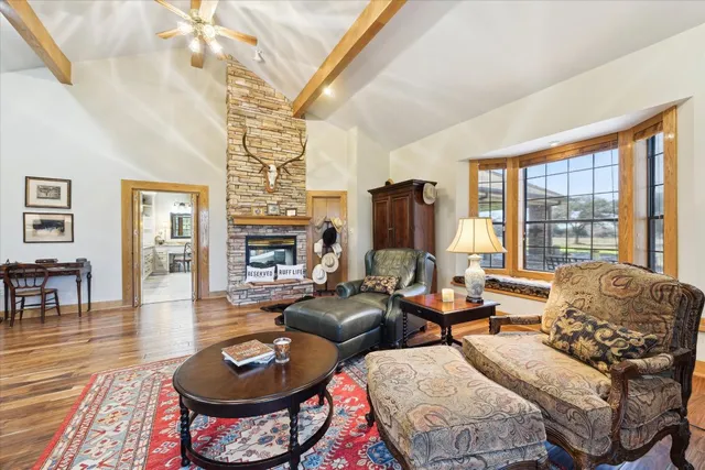 a living room with furniture kitchen view and a large window