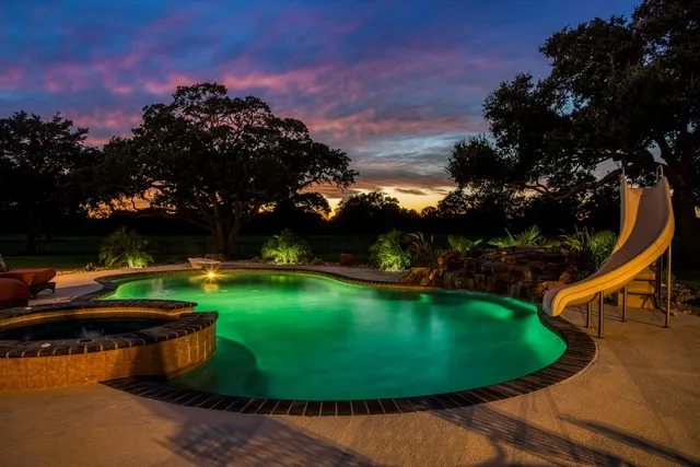 a kitchen with stainless steel appliances kitchen island granite countertop table chairs sink and cabinets