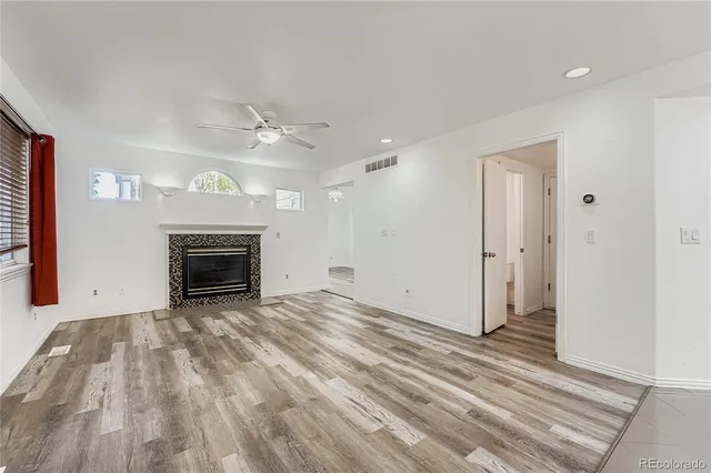 a view of empty room with wooden floor and fireplace