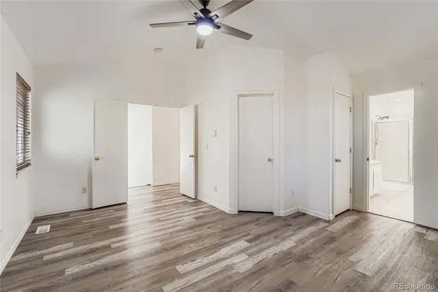 a view of a livingroom with wooden floor and a ceiling fan