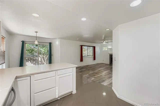 a kitchen with white cabinets and window