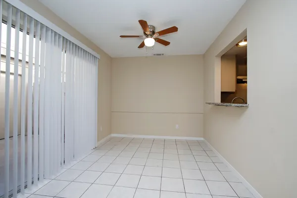 an empty room with a window and a ceiling fan