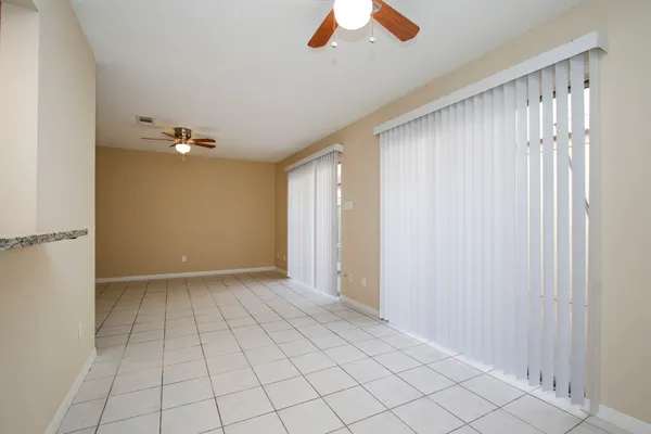 an empty room with a window and a fan
