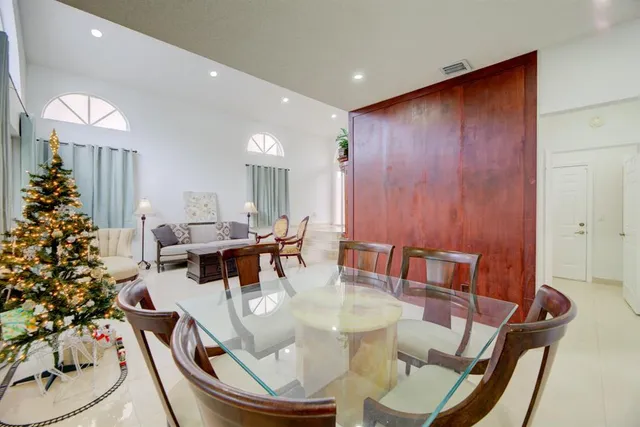 a dining room with furniture potted plants and wooden floor