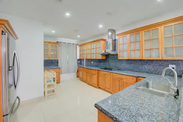 a kitchen with stainless steel appliances granite countertop a sink and a refrigerator