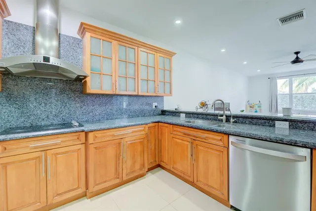 a kitchen with granite countertop a sink and white cabinets