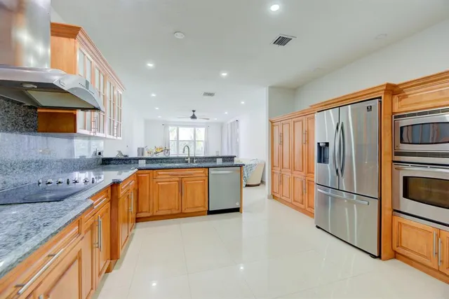 a kitchen with stainless steel appliances granite countertop a refrigerator a sink and a stove