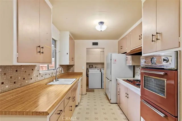 a kitchen with granite countertop a sink stove and refrigerator