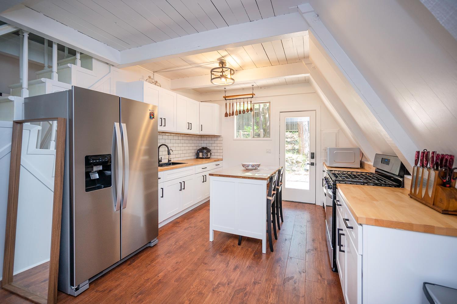 6141 Sweeney Road Somerset, CA 95684 - Photo 21 of 67 a kitchen with a refrigerator a stove a sink dishwasher and a dining table with wooden floor