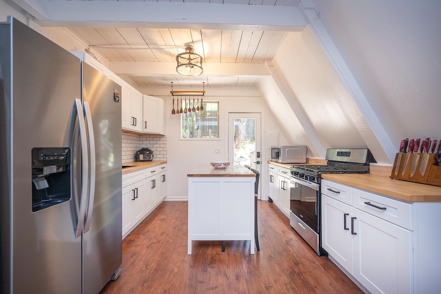 6141 Sweeney Road Somerset, CA 95684 - Photo 23 of 67 a kitchen with stainless steel appliances a stove a sink dishwasher a refrigerator white cabinets and wooden floor