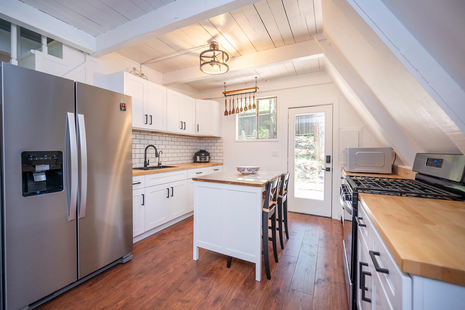 6141 Sweeney Road Somerset, CA 95684 - Photo 24 of 67 a kitchen with stainless steel appliances a refrigerator a stove a sink dishwasher and a refrigerator with wooden floor