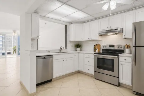 a kitchen with appliances a sink and a refrigerator