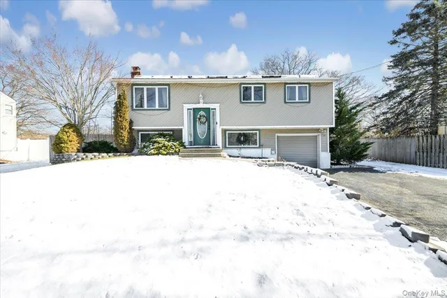a front view of a house with a yard covered with snow