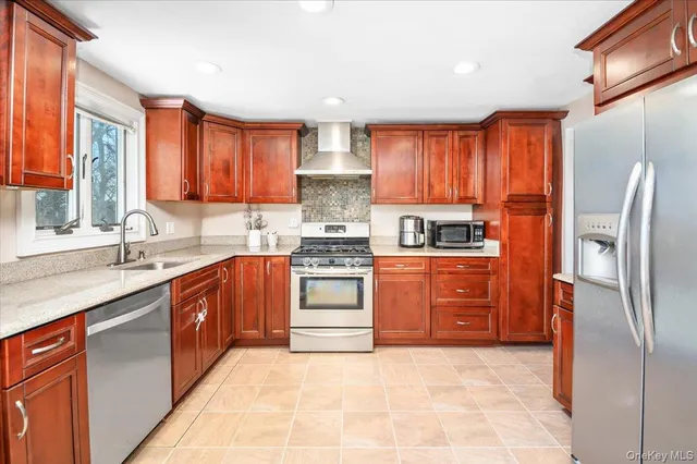 a kitchen with stainless steel appliances granite countertop a refrigerator stove and sink