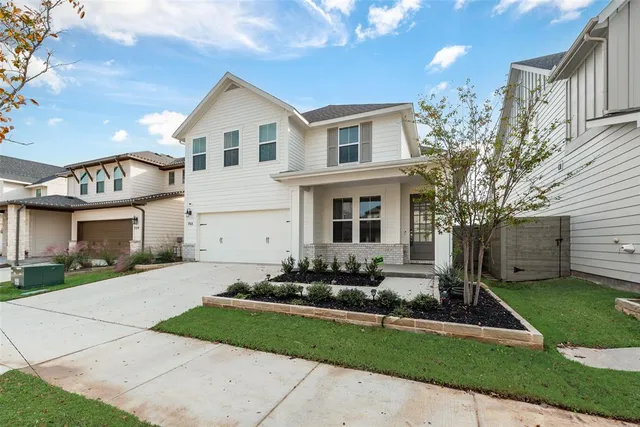 a front view of a house with a yard and a garden