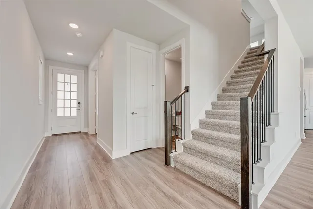 a view of a hallway with wooden floor and entryway