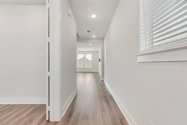 a view of a hallway with wooden floor