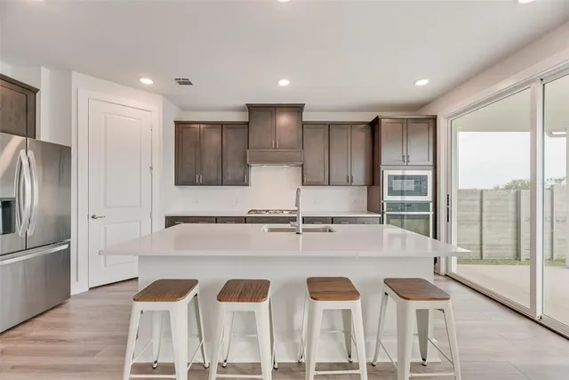 a large kitchen with lots of counter space and chairs