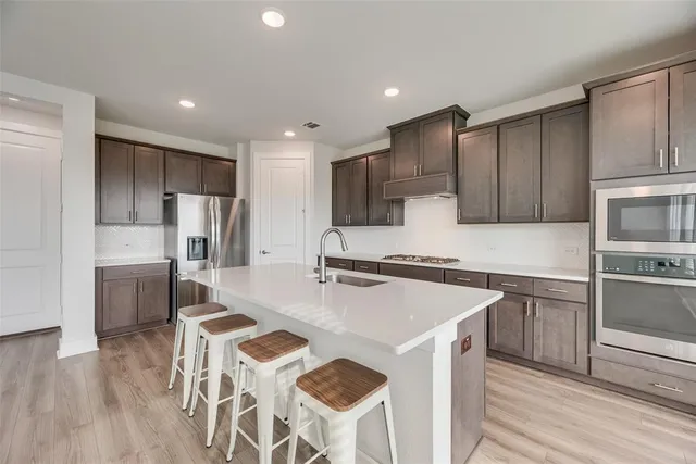 a kitchen with stainless steel appliances granite countertop a sink stove and refrigerator