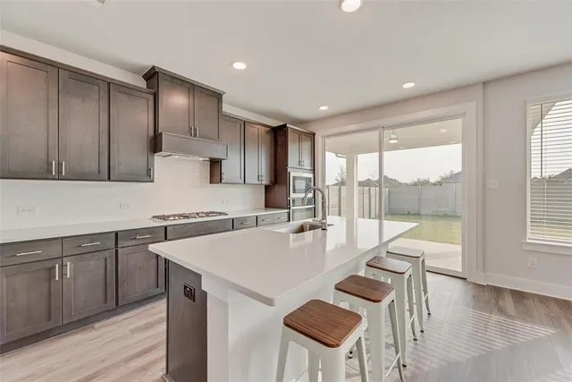 a large kitchen with a table and chairs in it