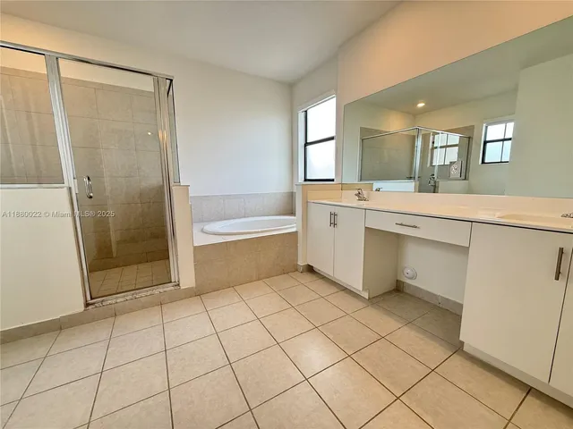 a spacious bathroom with a mirror and a bathtub