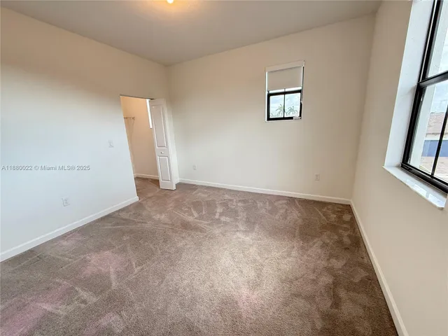 an empty room with windows and wooden floor