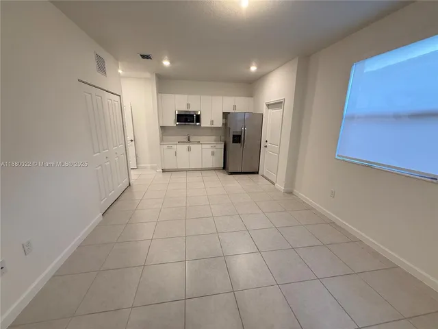 a view of a kitchen with an empty space and a window